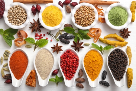 Colorful, aromatic Indian spices and herbs on a wooden white  background.の写真素材