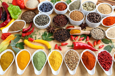 Aromatic and colorful spices in ceramic containers on a wooden background.の写真素材