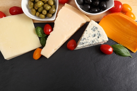 Delicacy. Food composition - different types of cheeses, olives and tomatoes.の写真素材