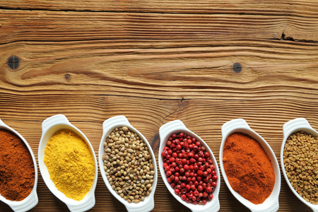 Spices in ceramic containers on wooden background. Food and cuisine ingradients.の写真素材