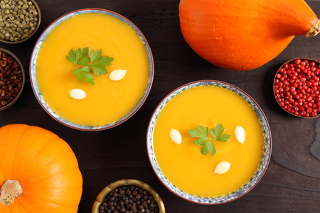 Pumpkin soup in bowls on wooden background. Top view.の写真素材