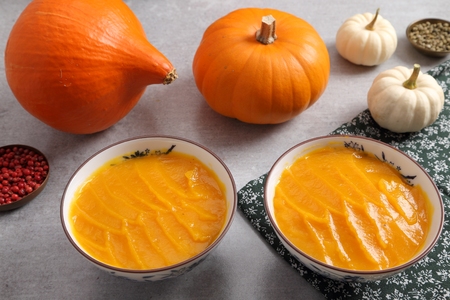 Pumpkin cream in bowls and spices on gray background.の写真素材