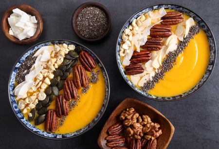 Smoothie bowl with pumpkin,  pecan nuts, chia seeds and coconut flakes.の写真素材