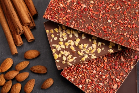 Chocolates with nuts and freeze-dried strawberies on dark background.の写真素材