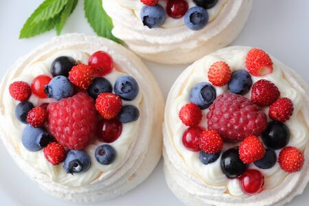 Dessert with berries on a meringue with cream.の写真素材