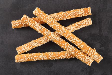 Bread sticks with salt and sesame seeds top view on a black background.の写真素材