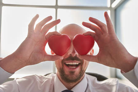 Happy man holding red hearts, love conceptの写真素材