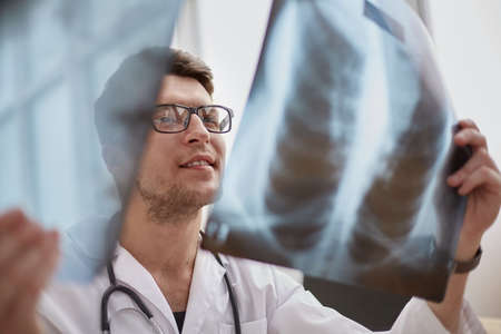 doctor in glass examining an x-rayの写真素材