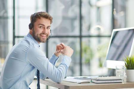Man with headphones and laptop working in officeの写真素材