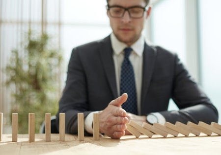 Businessman with dominoes in the office. concept business riskの写真素材