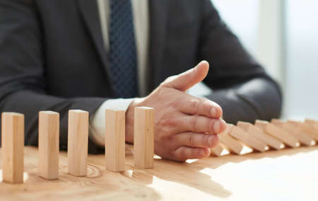 Businessman with dominoes in the office. concept business riskの写真素材