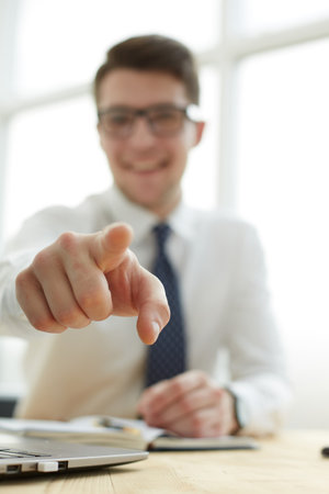 Handsome smiling businessman pointing his finger to youの写真素材