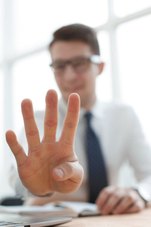 Young businessman man showing number four with fingers on handの写真素材