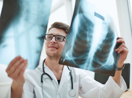 Male doctor radiologist examines x-rays in a medical office.の写真素材