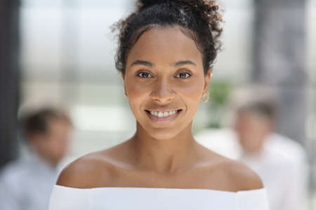a business woman smiling inside office buildingの写真素材