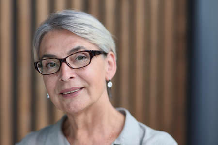 beautiful mature woman in office arms crossedの写真素材