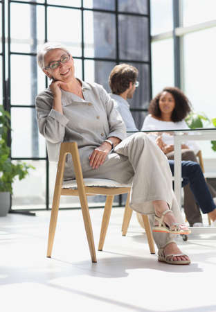 mature woman sitting with laptop looking at cameraの写真素材