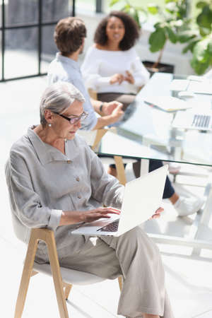 mature woman sitting and looking at laptopの写真素材