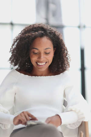 Portrait of a young attractive African American woman using a smartphoneの写真素材