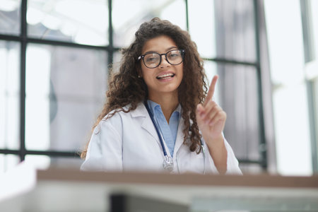 Doctor woman with warning gesture sitting at the table