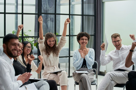 Business people with raised arms during seminarの写真素材