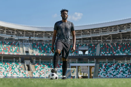 african american man holding a soccer ball in the stadium