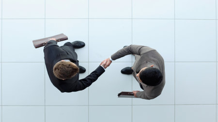 Business partners shaking hands as a symbol of unity, view from the topの写真素材