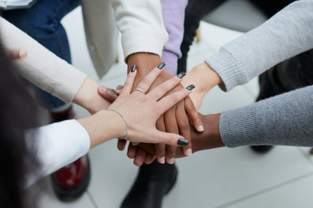 Diverse people sitting in circle holding hands at group therapyの写真素材