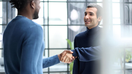 Headshot portrait of a smiling businessman offering a handshake. Business concept