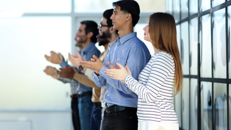 A group of people standing in a row clapping their hands