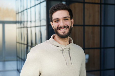 Smiling young businessman in a sweater posing. Achieving career wealth business concept.