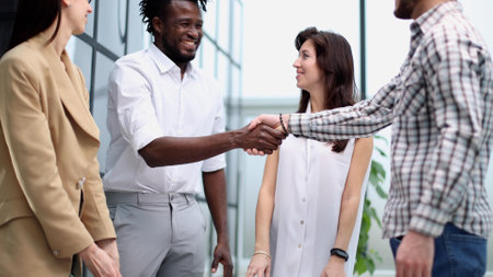 young businessman shaking hands with a colleague in the corridorの写真素材