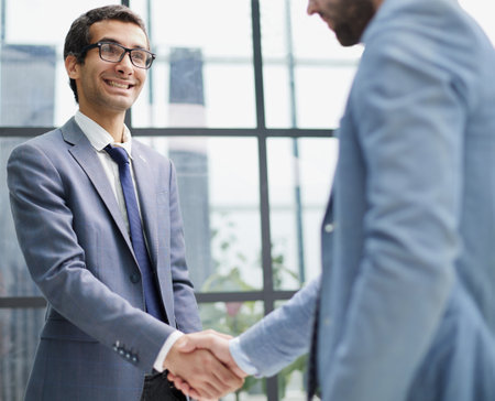 Two business men shaking hands together after successful meeting.の写真素材