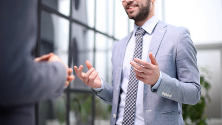 two businessmen discuss the document standing in the office lobby.