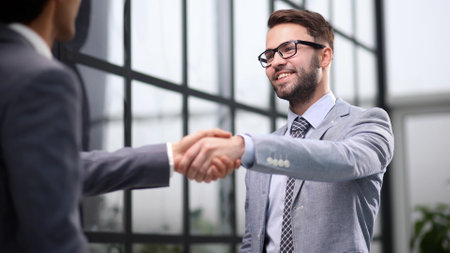 Happy businessmen greeting each other in the office.の写真素材