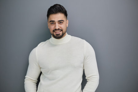 Handsome man in casual sweater looking at camera, positive person.の写真素材