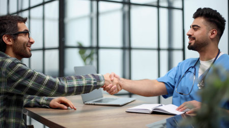 Nice doctor shaking hands with the patientの写真素材