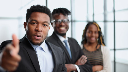 Confident businessman makes shooting gesture, recieves great successの写真素材