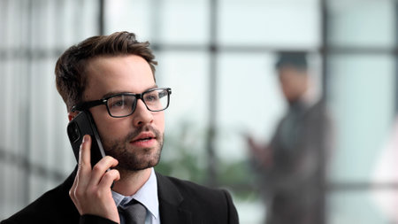 Close up cropped side profile portrait of a successful young man, having a business conversationの写真素材