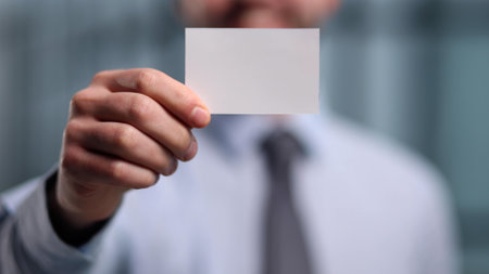 business man holding empty white business card in modern office building. Free blank copy space.の写真素材
