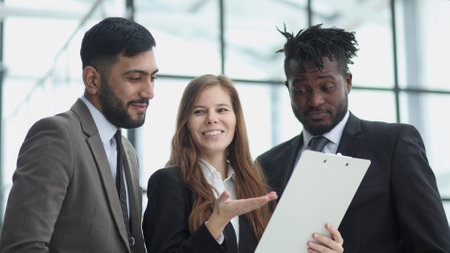 Business people talking with female colleague in office corridor