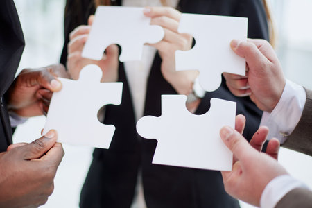 Group of business people assembling jigsaw puzzle and represent team support and help concept