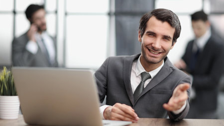 sitting at table investor shaking hand over table in office