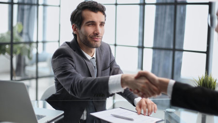 Happy business men giving handshakes after negotiationsの写真素材