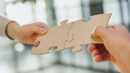 close up of business people connecting couple puzzle jigsaw, business solution concept.