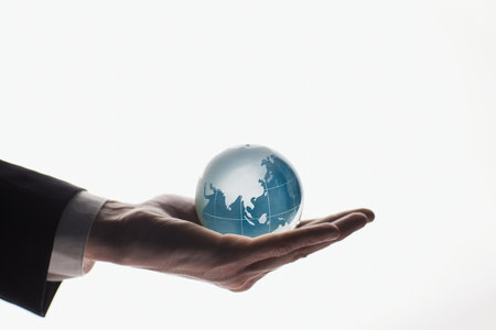 Businessman holding glass globe isolated on white backgroundの写真素材