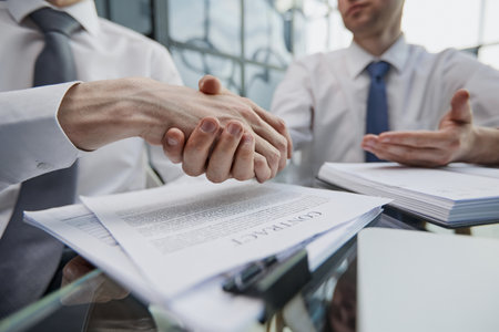 Close up businessman shaking hands with caucasian client.の写真素材