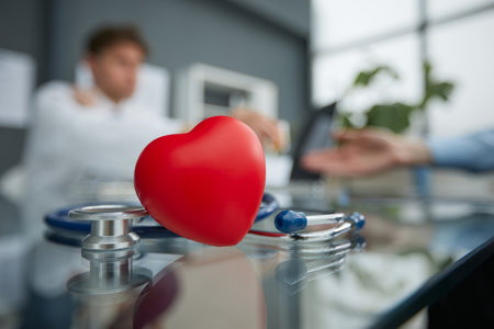 Stethoscope and red heart on wooden table. Cardiology conceptの写真素材