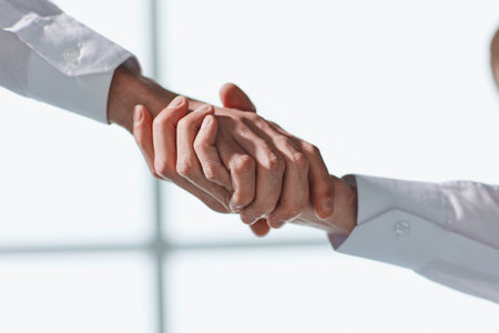 Businessmen in white shirts shaking hands close upの写真素材