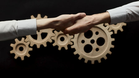 handshake on the background of a wooden mechanism. Black chalk board.の写真素材